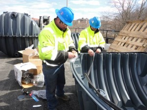 two irrigation technicians near large plastic container