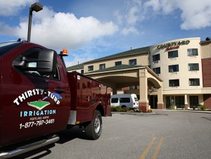 thirsty turf irrigation truck in front of hotel