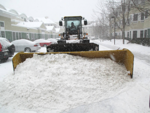 heavy equipment removing snow from apartments
