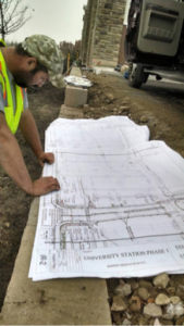 man looking at irrigation system blueprints