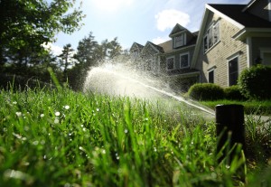 active sprinkler with home in background