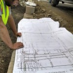 man looking at irrigation system blueprints