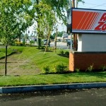 sprinklers watering lawn near AutoZone sign