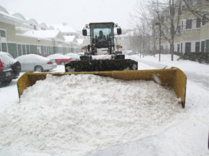 bucket loader removing snow from apartment complex